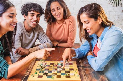 Jogos Para Grupos De Amigos - Um grupo de amigos jogando jogos de tabuleiro em uma mesa rindo e ...