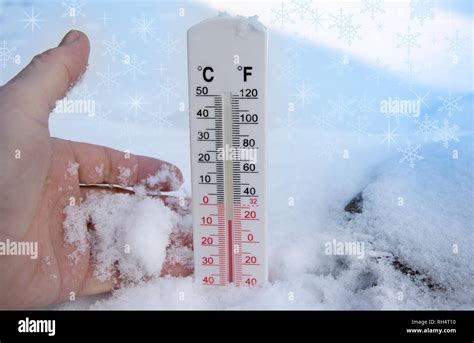 Thermometer on snow shows freezing temperature in celsius or farenheit ...