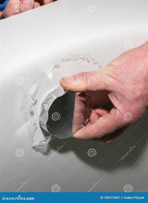 Bath Installation. Worker is Checking Drain. Maintenance Repair in the