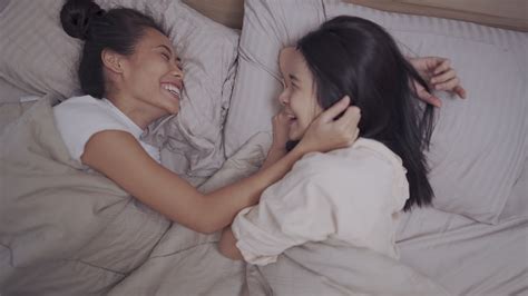 Asian two females lesbian couple cuddle inside blanket, holding hands