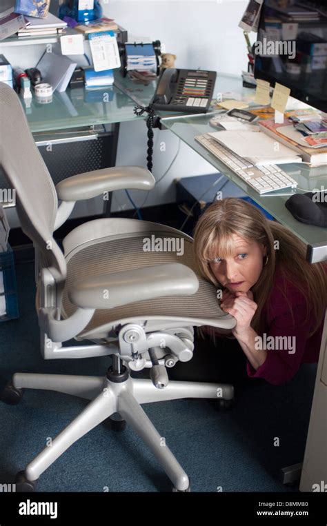 woman hiding  peeking     desk stock photo