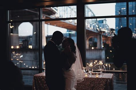 man and wife share a dance at their wedding reception with a bridge