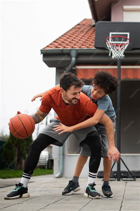 Padre e hijo jugando baloncesto juntos en casa en el patio trasero
