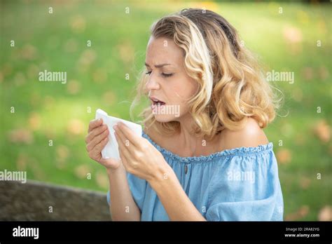 woman with with allergy symptom blowing nose Stock Photo - Alamy