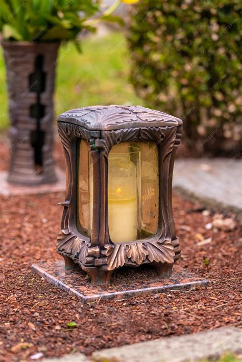 Premium Photo | Grave light with burning candle on a grave with flowers
