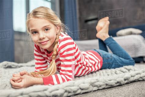 Pretty little girl lying on floor and smiling at camera - Stock Photo ...