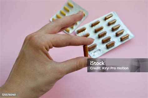 tablet coklat lonjong oval  tangan wanita persiapan  minum pil