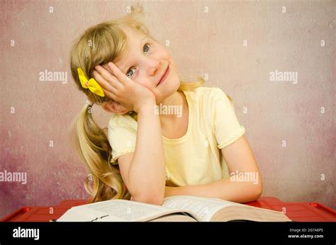 beautiful thoughtful blond girl with open book Stock Photo - Alamy