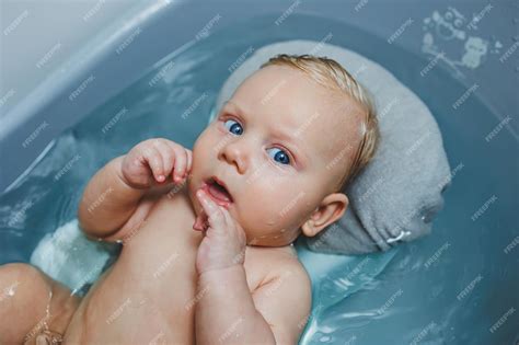 Premium Photo | Caring for a newborn baby bathing the baby Bathing a baby in a bathtub Babys ...