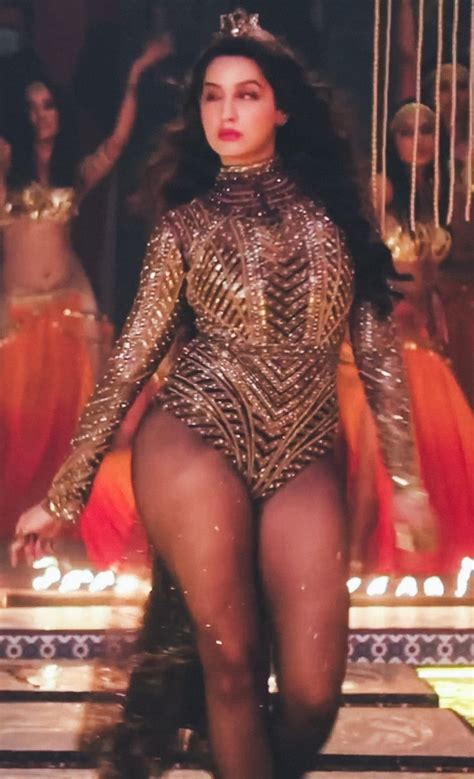 a woman in a gold bodysuit walking on stage