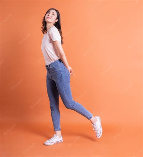 Premium Photo | Full length image of young Asian woman posing on orange