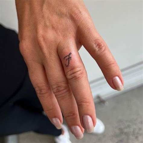 tattoo   letter  located   finger