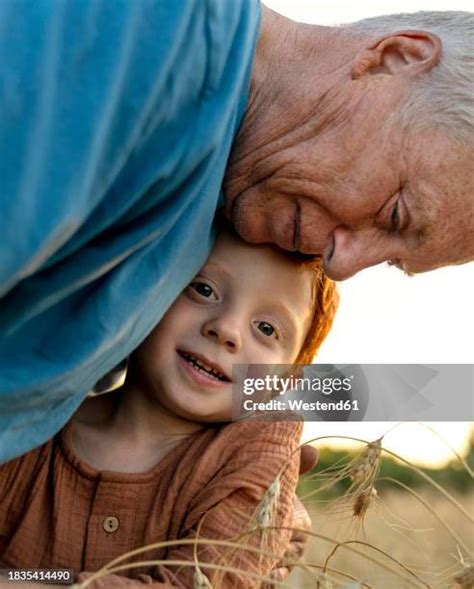 loving grandfather embracing grandson  crop plants high res stock