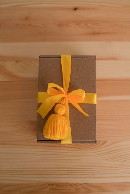 Premium Photo | Kraft box with yellow ribbon