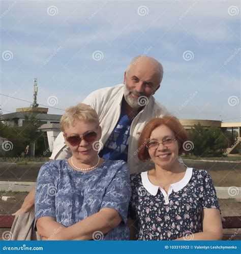 Dos Mujeres Maduras Se Sientan En Un Banco, Detrás De Ellos Un Soporte