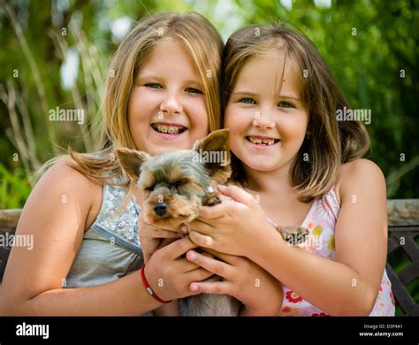 Happy smiling children playing with their pet - outdoor in backyard ...