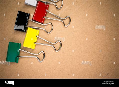 colored metal paper clips on a cardboard background Stock Photo - Alamy
