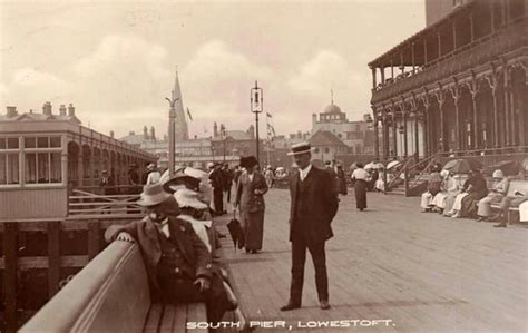 an old black and white photo of some people on a boardwalk with ...