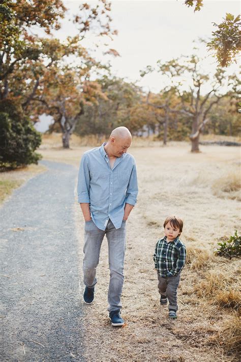 "Asian Dad Spending Time With Son Outside Walking In Nature" by Stocksy