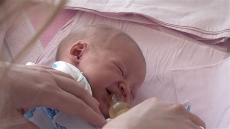 Mother giving bottle with water to sleepy newborn baby 28799023 Stock