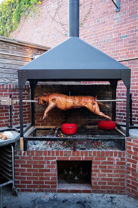 "Fire Roasted Whole Hog Cooking On Spit" by Stocksy Contributor "Andrew