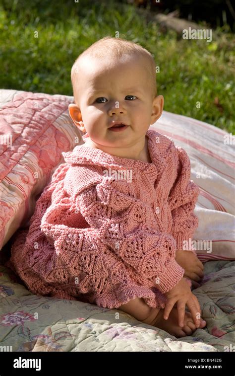 Portrait of a baby girl wearing a pink hand knitted dress Stock Photo ...