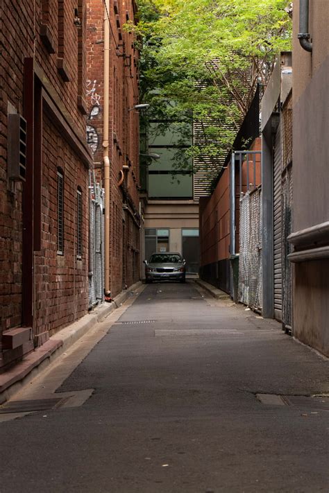 Download Car Passing Through Alley Background | Wallpapers.com