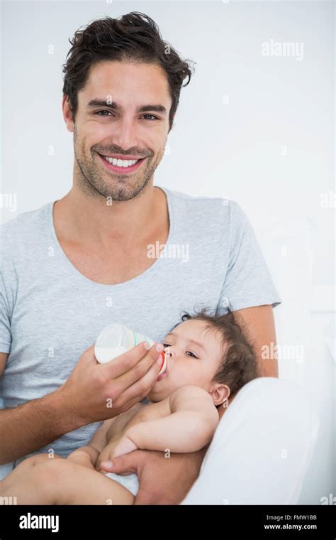 Man feeding milk to baby girl Stock Photo - Alamy