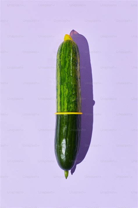 Minimal shot of single cucumber with condom on pastel background safe
