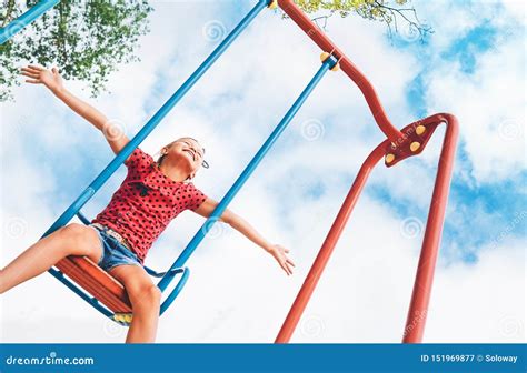 funny smiling  girl swinging   swing wide opened  arms