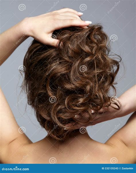 Back View Portrait of Beautiful Young Dark Brunette Woman on Gray