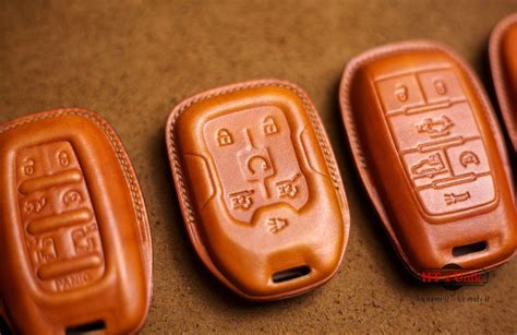 four leather car keys are lined up on a table