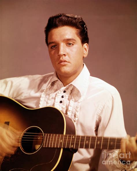 Elvis Presley Playing Guitar by Bettmann