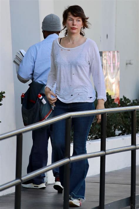 Milla Jovovich in a Distressed White Top Paired With Some Flared Blue