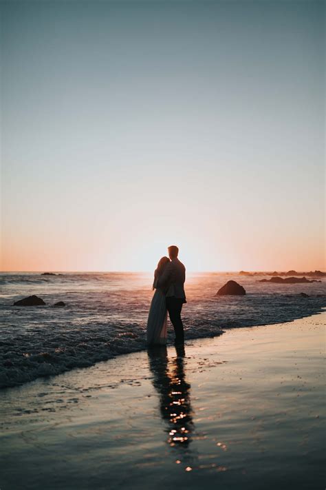 Download Couple At Beach During Sunset Wallpaper | Wallpapers.com