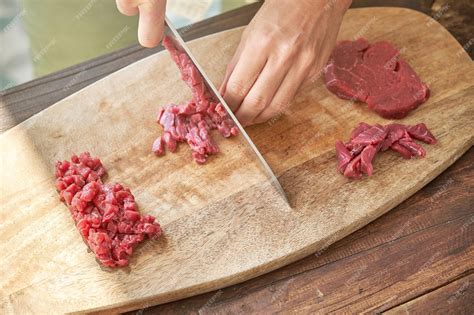 premium photo crop cook chopping meat  wooden board