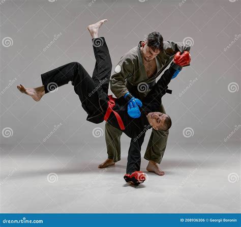 Two Fighting Guys in Kimono and Boxing Gloves during Battle, Knockout