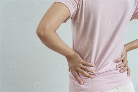 woman holding her lower back while and suffer from unbearable pain