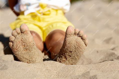 Premium Photo | Barefoot kid on sandy beach child feet in sand in sunny ...