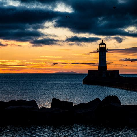 Download wallpaper 3415x3415 stones, lighthouse, silhouette, sea
