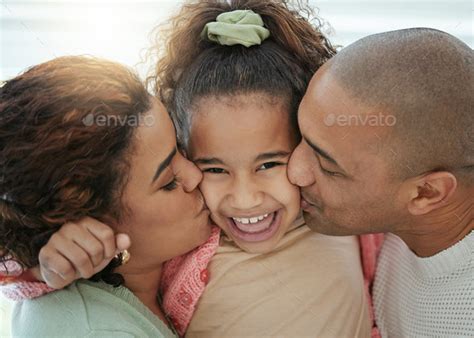 Shot of an adorable little girl getting kisses on her cheeks from her ...