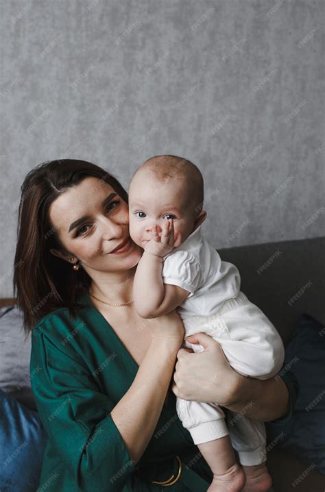 Una joven y gentil madre feliz abraza a su bebé recién nacido