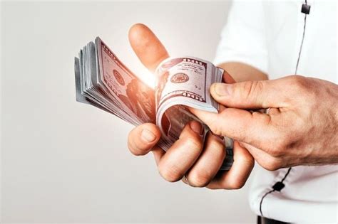 Бизнесмен держит доллары в руках. богатый человек считает деньги в ...