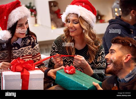 Cheerful friends exchanging presents at Christmas eve Stock Photo - Alamy