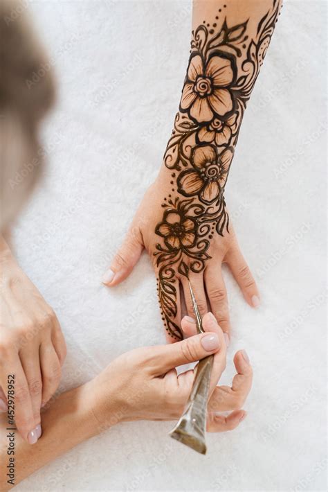 Artist applying henna tattoo on women hands. Mehndi is traditional