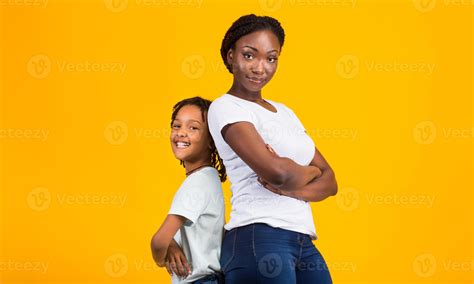 Confident Women. Black mom and her kid standing back to back with