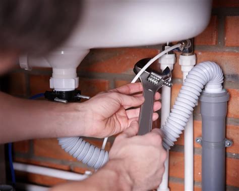 Premium Photo | Plumber repairing sink pipes in kitchen closeup