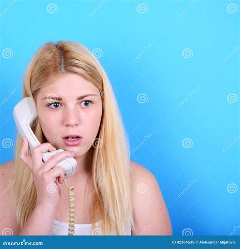 Portrait of Young Female in Shock while Talking on Phone Having Stock