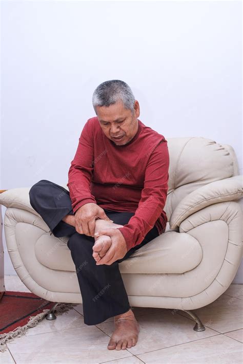 Premium Photo | Elderly Asian man massaging his aching feet with his