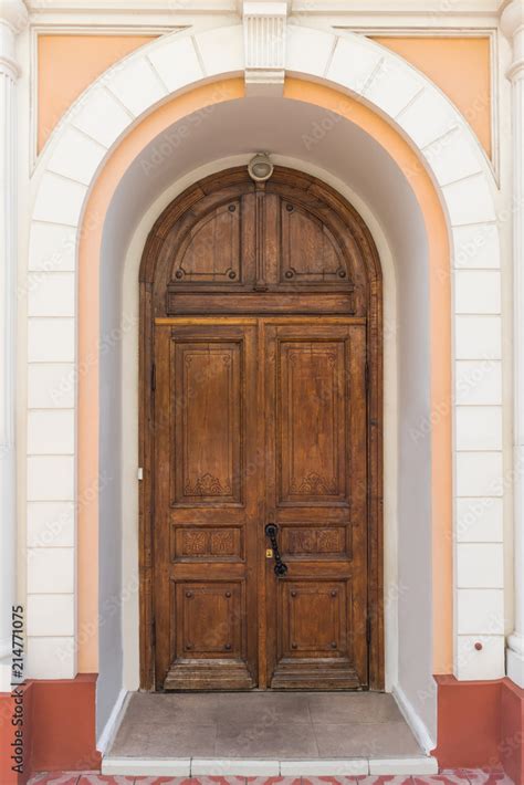 Wooden door of an old mansion with an arch Stock Photo | Adobe Stock